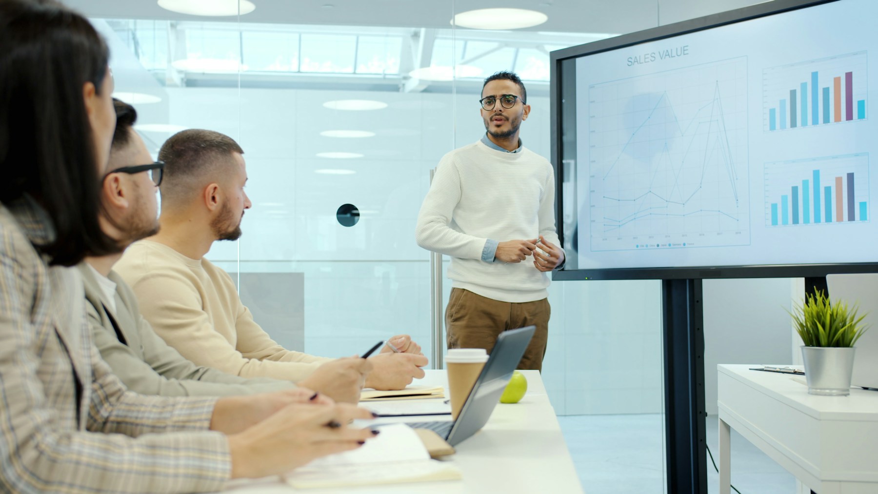 Formateur présentant une analyse de données à des collaborateurs en formation